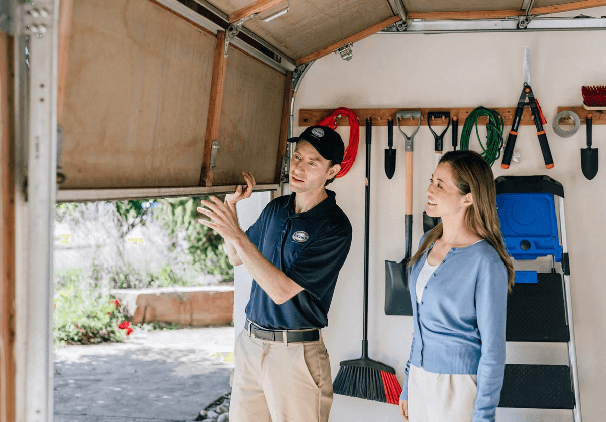 Garage door technician explaining repair to homeowner